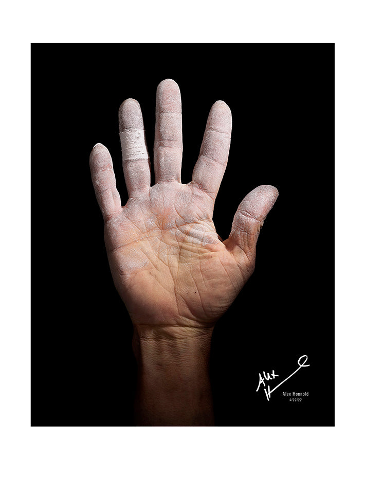 Alex Honnold's hand on black background with autograph